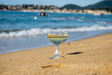 Summer time on French Riviera, two coupe glasses of champagne cremant sparkling wine on Pampelonne sandy beach near Saint-Tropez in sunny day, Var, vacation in France
