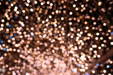 A mesmerizing display of warm golden bokeh lights against a dark background, evoking a festive and cozy atmosphere.