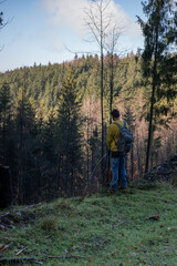 Obraz premium Male hiker with a backpack urinates in the forest. 