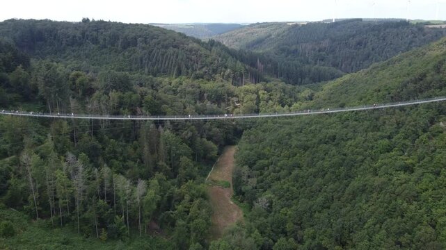 M&ouml;rsdorf, Germany - August 19th 2024: Drone flying towards and over the center of the Geierlay Suspension Bridge.