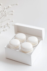 Obraz premium White Macarons Neatly Placed in a Pristine White Box on a White Background