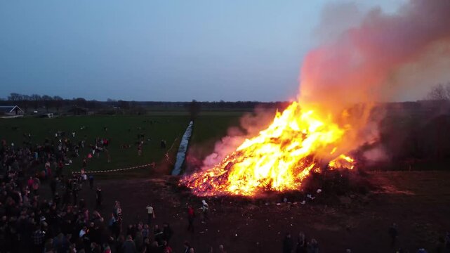 Elsloo, the Netherlands - April 9th 2023: Drone moving away from people gathering around the annual Easter bonfire.