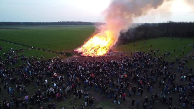 Elsloo, the Netherlands - April 9th 2023: Drone moving towards people gathering around the annual Easter bonfire.