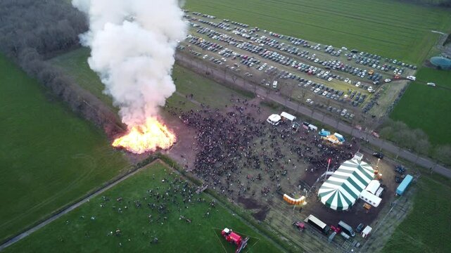 Elsloo, the Netherlands - April 9th 2023: Top Down drone footage of people gathering around the annual Easter bonfire.