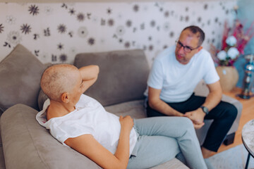 A woman suffering from cancer in a deep with her husband, representing connection, understanding,...