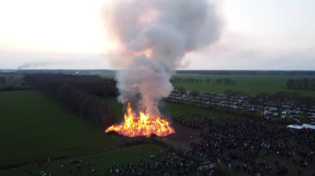 Elsloo, the Netherlands - April 9th 2023: Drone footage of people gathering around the annual Easter bonfire.