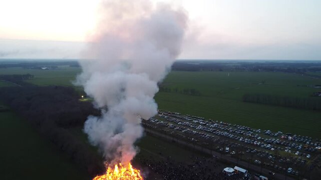 Elsloo, the Netherlands - April 9th 2023: Drone footage of people gathering around the annual Easter bonfire.