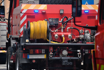 Fototapeta premium Rear of fire engines on an emergency mission, in a city's capital, saving lives and protecting others