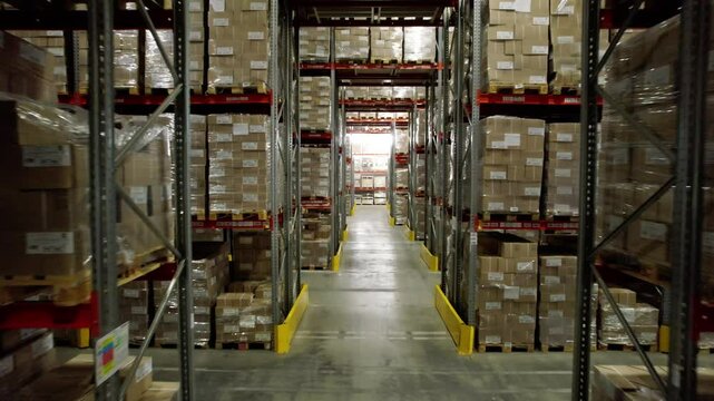 Premise of cardboard factory warehouse for storing finished products. Room contains high shelves for storing materials with information stickers