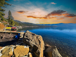 a gorgeous winter landscape at Lake Tahoe with blue lake water, lush green trees and plants and...
