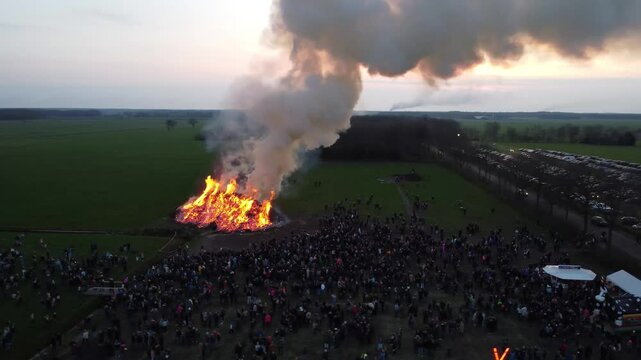 Elsloo, the Netherlands - April 9th 2023: Drone footage of people gathering around the annual Easter bonfire.