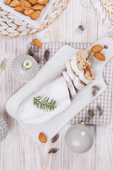 A festive scene with sliced stollen bread, holiday decorations, almonds, and ornaments, showcasing the traditional dessert in a cozy and seasonal atmosphere.