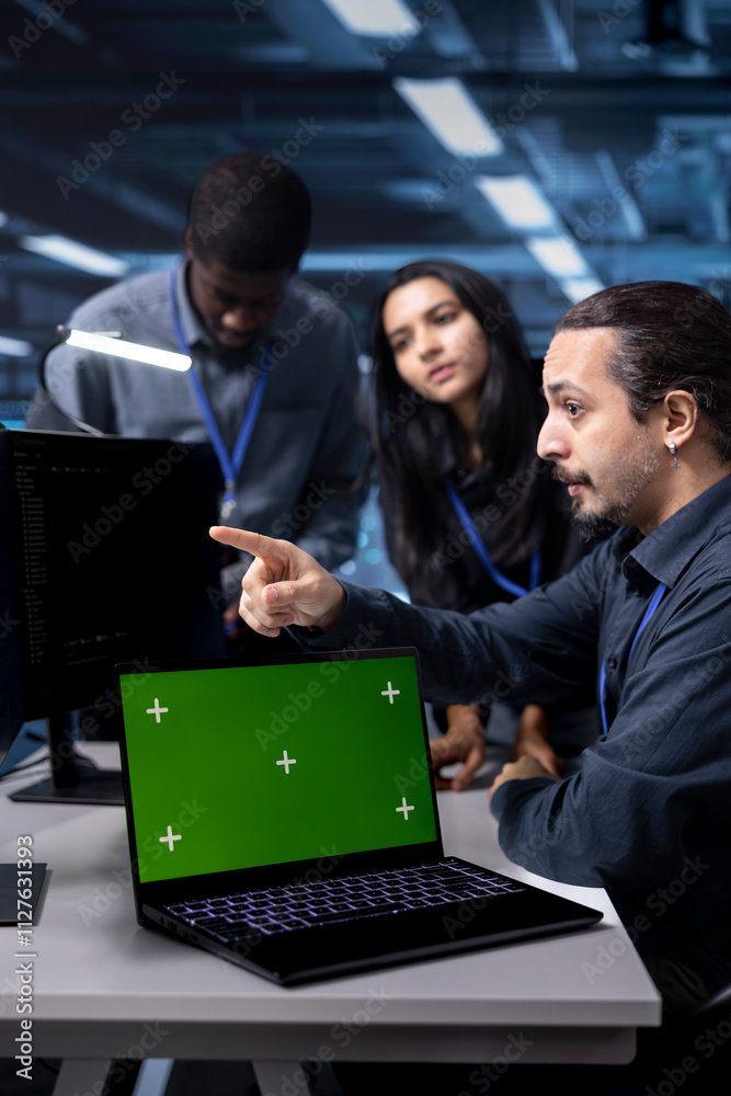 Poster multiethnic team of engineers in data center using system monitoring software on green screen laptop
