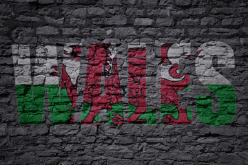 painted national flag with text wales on a old brick wall
