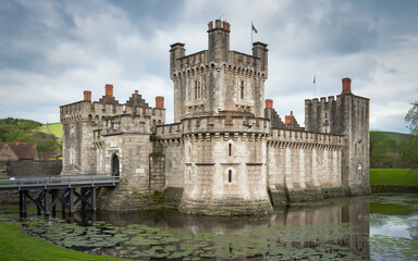 Obraz premium Historic castle surrounded by water in a peaceful rural setting with lush greenery