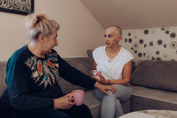 Woman with cancer support. Two women engage in a heartfelt conversation over a cup of tea,...