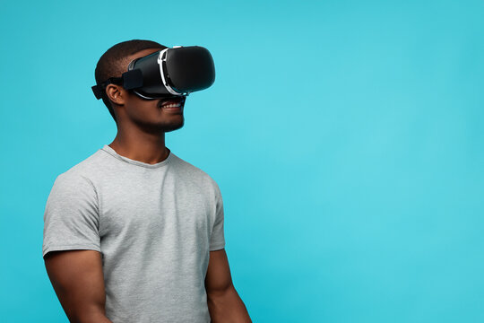 Man wearing virtual reality headset. Guy wearing glasses and blue background. A young guy in blue glasses and technology with a viar. A young guy in glasses and technology is a lifestyle future guy.