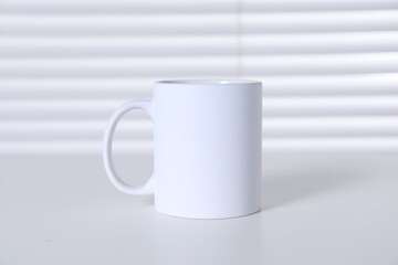 Obraz premium One blank ceramic mug on white table. Mockup for design