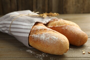 Freshly baked baguettes on wooden table, closeup