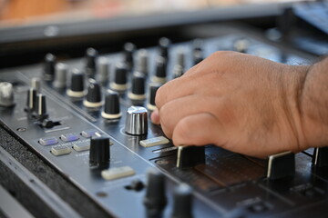 Un Dj mezclando música desde una consola de sonido