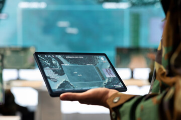 Navy operations engineer following enemy warship trajectory on CCTV radar imagery, ensuring...