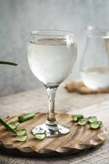 A glass of natural aloe vera juice with fresh sliced leaf