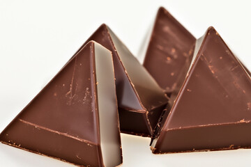 Three triangular pieces of are shown. Chocolate triangle with white background. Chocolate triangle...