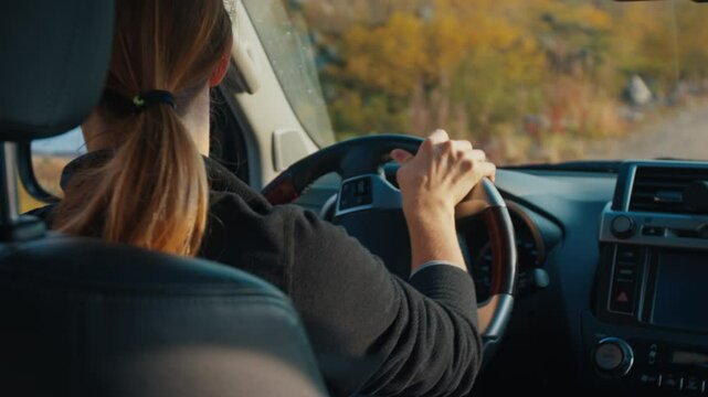 Young woman steers the big 4x4 car on a bumpy unpaved road