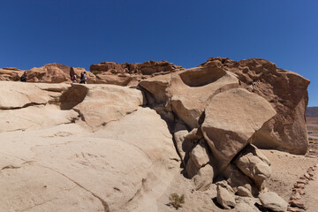 personas sobre mont&iacute;culo e petroglifos de Yerbas Buenas, San Pedro de Atacama, desierto de Atacama, Chile