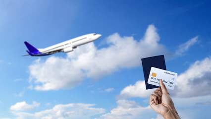 Human hand holding a passport and credit card with flying commercial airplane in the sky background