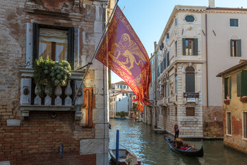 Gondola on canal and venetian flag, Venice, Veneto, Italy