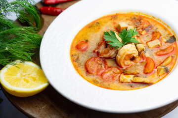 Prepared Tom Yum in a white bowl with shrimp.