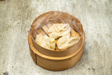 Chinese dim sum dumpling on bamboo wooden basket bowl on wooden table