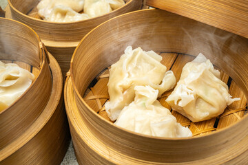 Assorted chinese dim sum dumpling on bamboo wooden basket bowl on wooden table