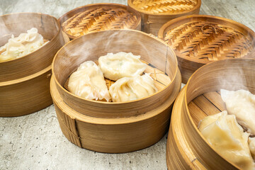 Assorted chinese dim sum dumpling on bamboo wooden basket bowl on wooden table
