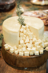 Cheese sliced. Decorated cheese, festive food on wooden table. Expensive and modern restaurant