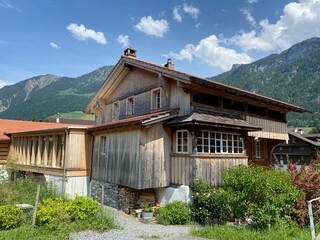Fototapeta premium Traditional rural architecture and family livestock farms on the shores of Lake Lungern - Canton of Obwald, Switzerland (Traditionelle Architektur am Ufer des Lungernsees - Schweiz)