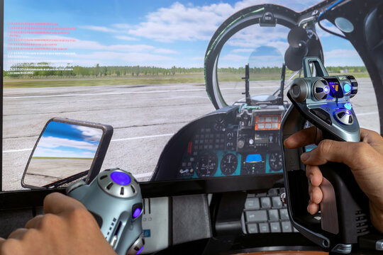 Man's hand holds joystick X52 in front of flight simulator screen