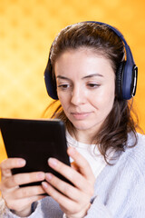 Woman reading ebook on ereader while listening music, enjoying hobby, relaxing. Bookaholic person...