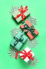 Beautiful Christmas composition with gift boxes and snowflakes on green background