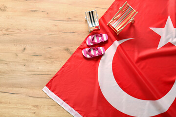 Flag of Turkey with mini beach chairs and flip-flops on wooden background