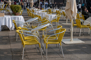 tables and chairs of an outdoor restaurant in the square of a tourist resort, outdoor area or dehor of customers. on holidays tourism makes the news, many events in cities of art, encourage travel.