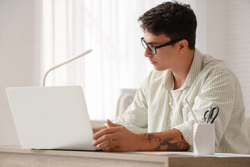 Fototapeta premium Male economist working with laptop at table in office