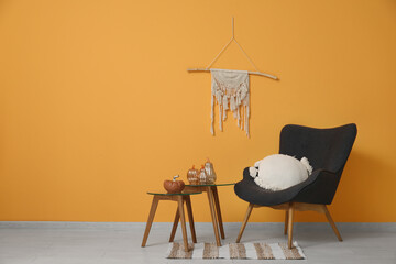 Interior of living room with armchair and decorative pumpkins on tables