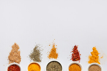 Composition with bowls of different spices on grey background