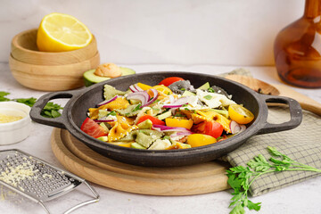 Frying pan with delicious Italian pasta salad on table