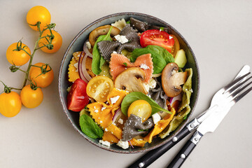 Bowl with delicious Italian pasta salad on grey background