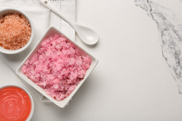 Bowls with scrub and ingredients on light background