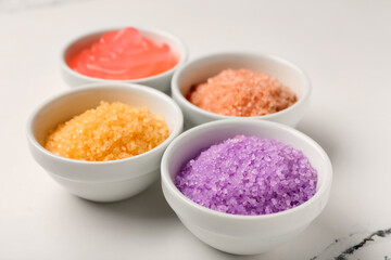 Bowls with scrubs on light background