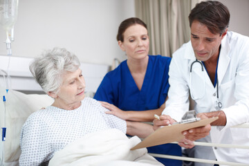 Doctor, clipboard and senior patient in hospital bed for healthcare results, surgery information and bad news. Elderly woman, nurse and health support for diagnosis, illness update and compassion